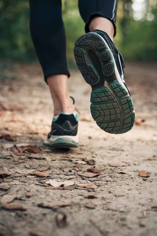 Autumn run in the nature on a trail with dry yellow leaves