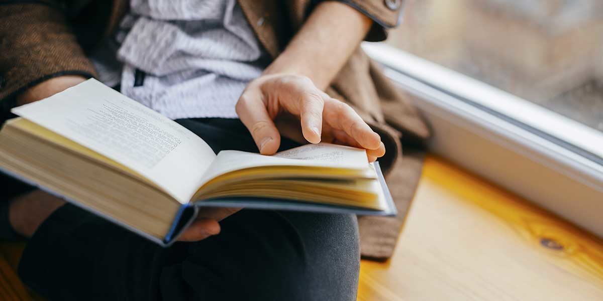 close-up of person holding book